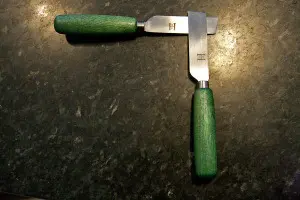 A pair of HDR Precision tip-cutting Knives with green handles.