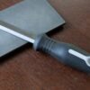 A left-handed knife with a handle on a wooden surface.