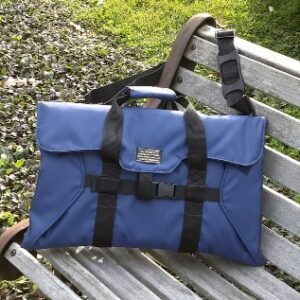 A blue briefcase belonging to a professional oboist sitting on a wooden bench.