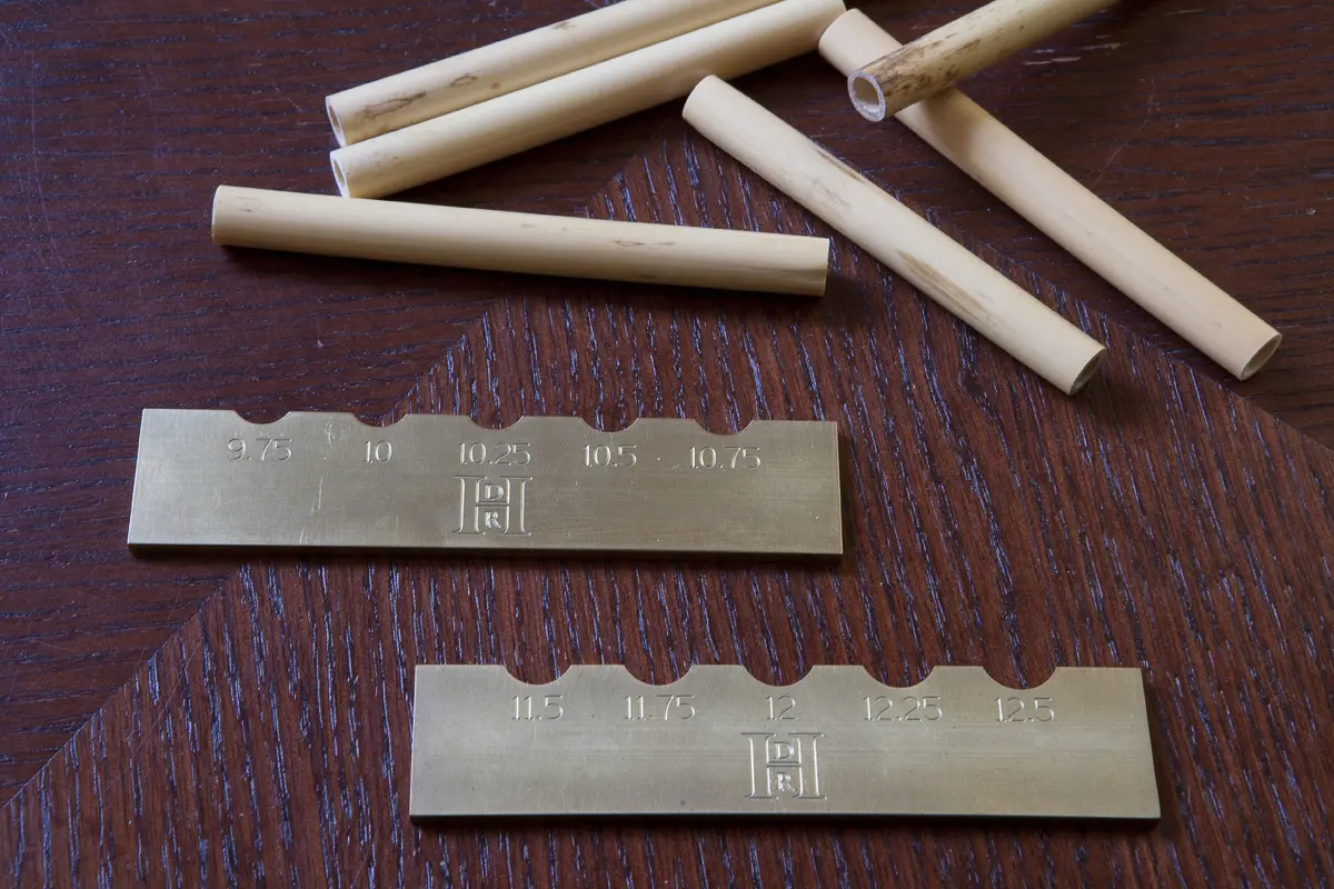 A group of brass rods on a wooden table.